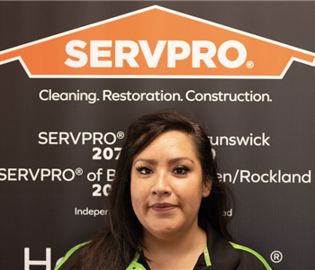 SERVPRO employee in front of logo